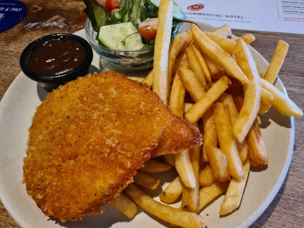 Golden crumbed Chicken Schnitzel with chips and salad served at Commercial Hotel pub in Parramatta, Sydney