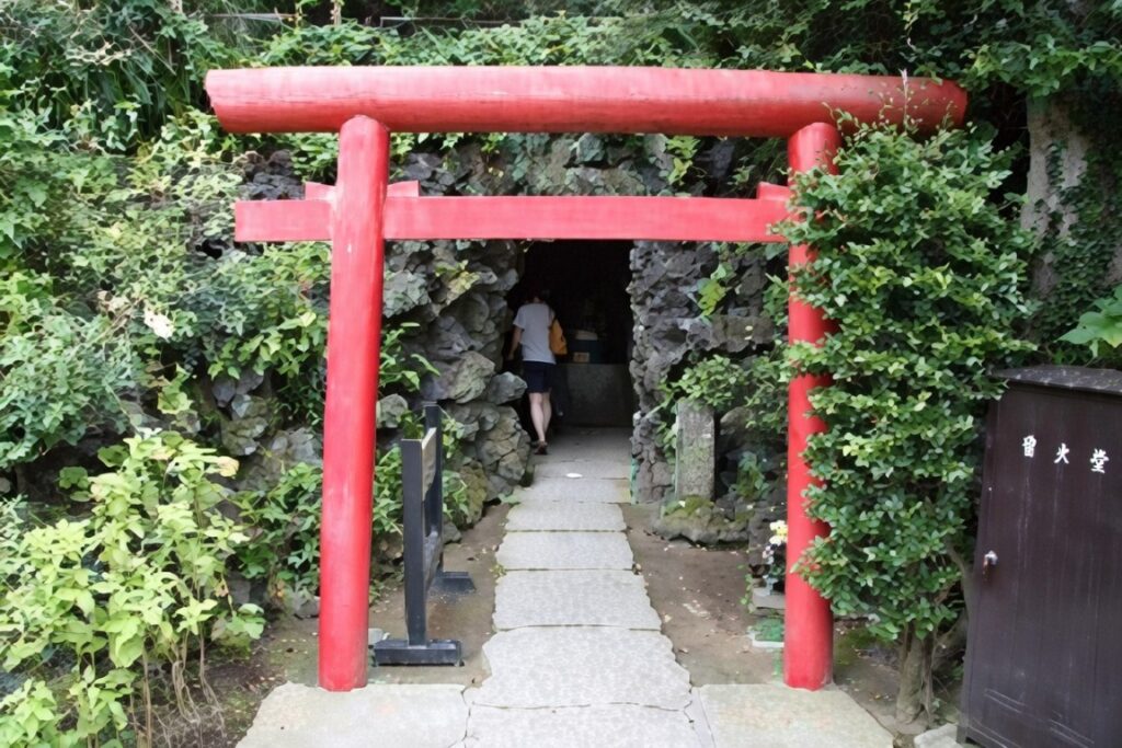 Red torii gate entrance to Benten-kutsu Cave at Hase-dera Temple Kamakura Japan – rock cave shrine