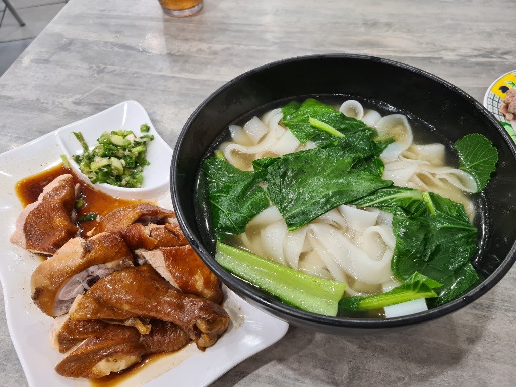 Plate of glossy soy sauce chicken next to steaming noodle soup with Chinese greens at Sun Ming BBQ Restaurant Parramatta – authentic Cantonese soy chicken (油雞) and 油雞湯麵 with bok choy, Church Street