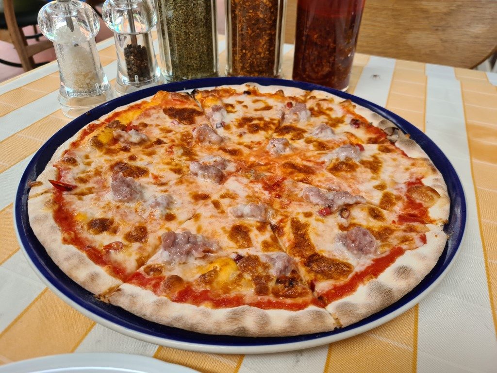 Freshly baked pizza with toppings at Pizzeria Limoncello Italian restaurant on Soi 11 Sukhumvit, Bangkok, Thailand