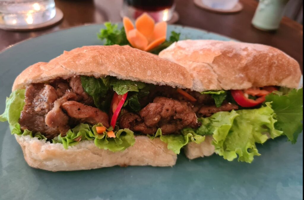 Pork Banh Mi Vietnamese sandwich with grilled pork, pickled vegetables, and herbs at Saigon Cafe in Sanur, Bali